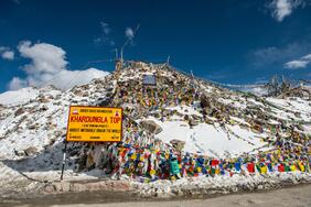 Khardung La pass snow covered road and high altitude mountains